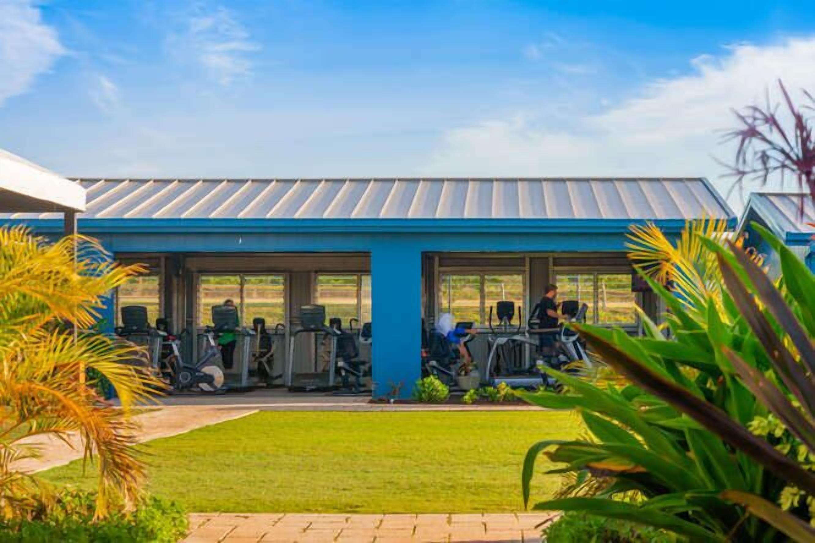A gym with exercise equipment and a covered area.