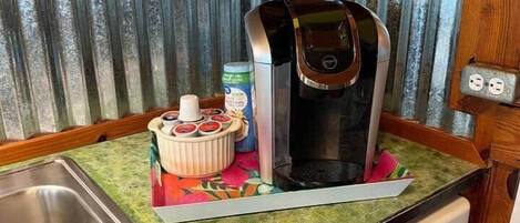 Et lille køkken med kaffemaskine, vask og opvaskemaskine.