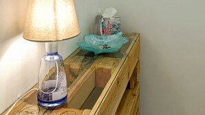 En træbænk med en lampe, et spejl og nøgler på væggen.
