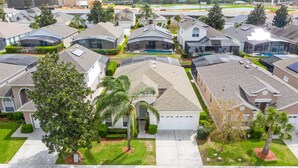 Un quartier résidentiel où les maisons se distinguent par leurs toits inclinés, leurs panneaux solaires et une piscine centrale.