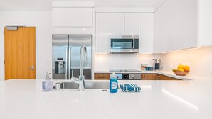 A modern kitchen with white cabinetry, stainless steel appliances, and a clean countertop.