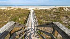 A wooden boardwalk leading to a beach with dunes and the ocean in the background. - Atlantic Blue (St. Augustine)