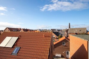 Ein Wohngebiet mit roten Ziegeldächern, Backsteinhäusern und blauem Himmel.