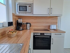 Eine moderne Küche mit Mikrowelle, Kaffeemaschine, Toaster und Backofen.