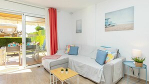 A modern, well-lit room with a sofa, a small table, and a lamp. - Wonderful  villa for 6 guests with pool, A/C, WIFI, TV and terrace (L'escala)