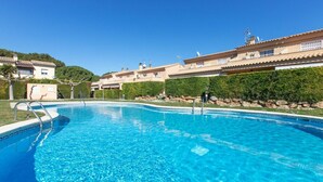 A clear blue swimming pool surrounded by a landscaped area with a building in the background. - Wonderful  villa for 6 guests with pool, A/C, WIFI, TV and terrace (L'escala)