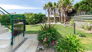 Un giardino con diverse piante, una scala verde e un recinto.