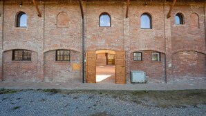 A brick building with arched windows and a central doorway. - Nice apartment for 3 guests with WIFI, TV, patio and pets allowed (Mondovì)