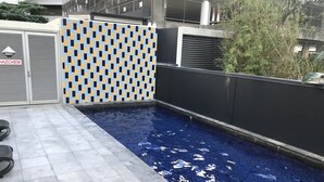 En pool på taket med ett kaklat golv och en vägg med ett rutmönster.