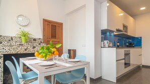 Eine moderne Küche mit weißen Schränken, einem eingebauten Backofen und einer blauen Spritzschutzwand.