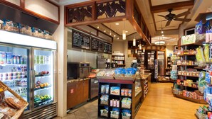 A grocery store interior with refrigerated sections, a deli counter, and shelves stocked with various food items.