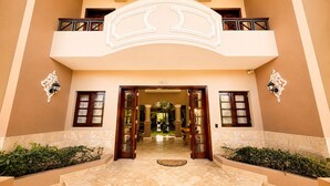 Entrada de hotel con puertas dobles, un balcón y el número 438 sobre la puerta.