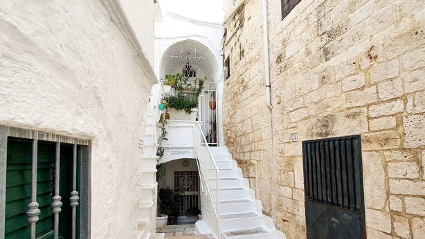 Un estrecho callejón con una escalera que lleva a la entrada de un edificio.