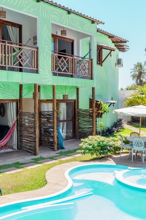 A two-story building with a swimming pool, a balcony, and a garden area. - Hana Mana Flats (São Miguel dos Milagres)