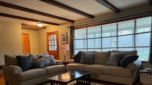 A living room with two sofas, a coffee table, and a large window. - 8 bed Lodge Near Camelback/Outlets-HOT TUB (Tannersville)