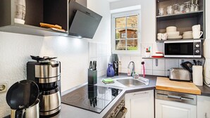 Una cocina moderna con estufa integrada, cafetera y microondas.