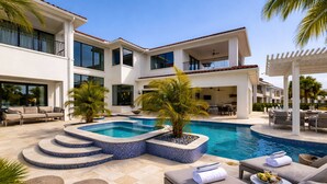 A modern pool area with a hot tub, lounge chairs, and outdoor furniture. - Luxurious Oasis with Immersive Circus Bedroom at Reunion (Kissimmee)