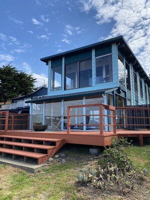 A two-story house with a large deck and a covered patio area. - Oceanfront Oasis, Sunsets & Crashing Waves (Moss Beach)