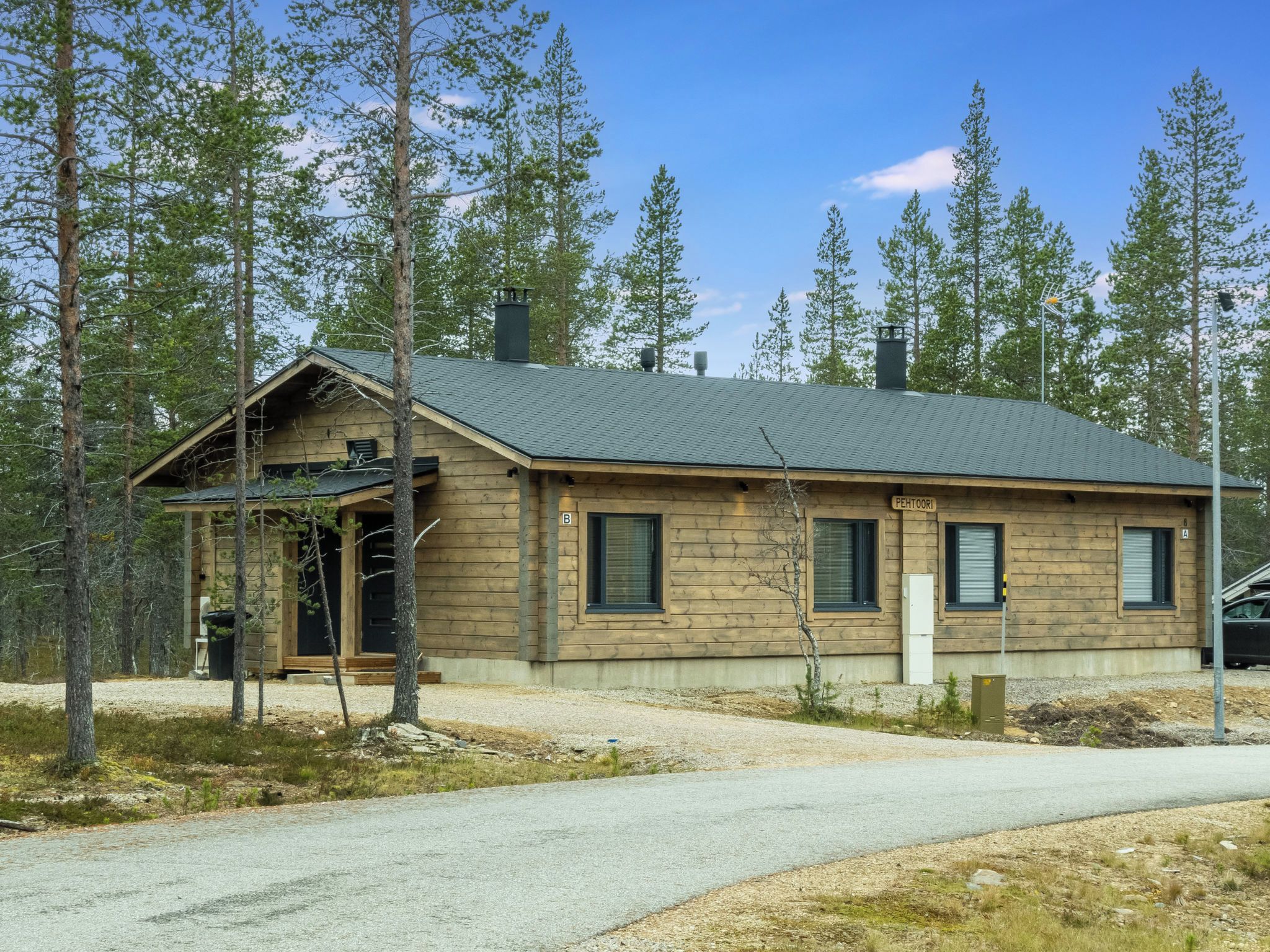 A wooden cabin with a sloped roof, a chimney, and a small porch.