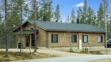 En stuga av trä med ett sluttande tak, en skorsten och en liten veranda.