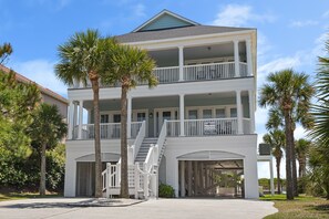 A multi-story beachfront property with balconies, palm trees, and a clear sky. - Wicker Cottage, 7 Bedroom Oceanfront Luxury Home with Private Pool (North Myrtle Beach)