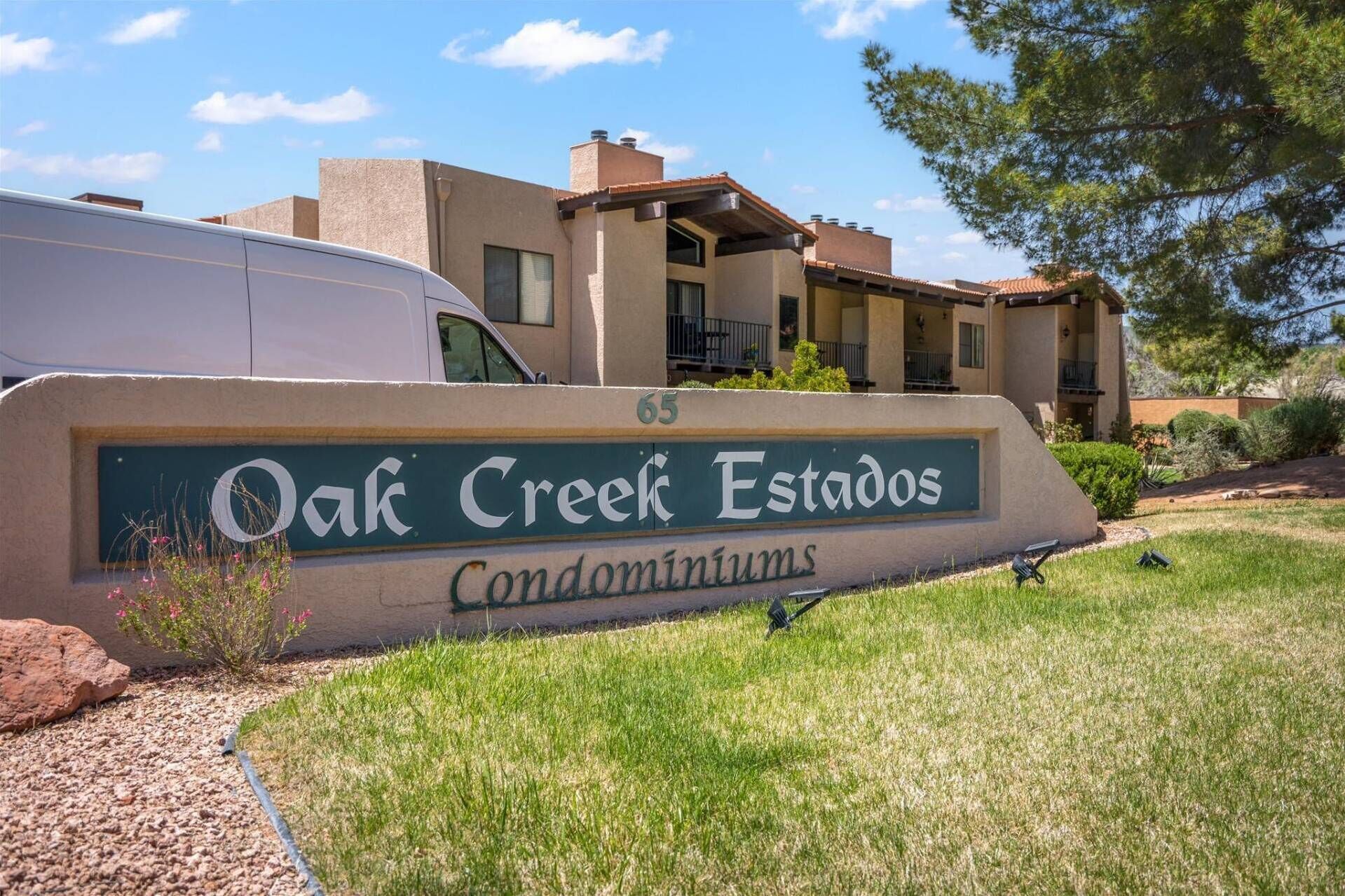 Señal de los Condominios Oak Creek Estates, con vista despejada del exterior del edificio.