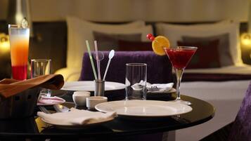 A hotel dining table set with plates, glasses, and a martini glass with an orange garnish.