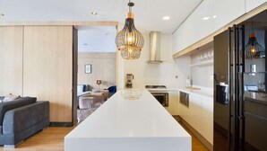 A modern kitchen with a central island, a dining area with a sofa and chairs, and a separate living area with a couch. - ONE BEDROOM HUGE BALCONY IN ENERGY ROOF POOL (Medellin)