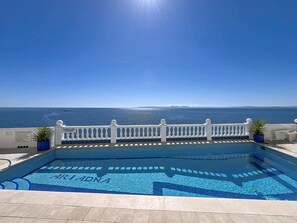 A swimming pool with a view of the sea and a white fence. - ARIADNA Rosas / Roses - INTER immo (Rosas / Roses)