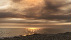 A beach with the sun reflecting off the water, clouds in the sky, and a sandy shore. - Gîte for two with private pool 20 minutes from Narbonne (Montséret)