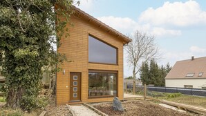 A modern wooden house with a large window and a door. - Wintersbourg Spa Retreat (Wintersbourg)