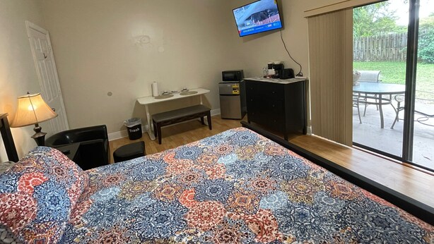 Ein Hotelzimmer mit Bett, Schreibtisch, Fernseher und Blick ins Freie.