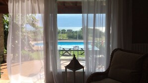 A room with a view of a swimming pool and greenery. - Villa Corneghe with Lake View, Pool, Garden, and Terrace (Gargnano)