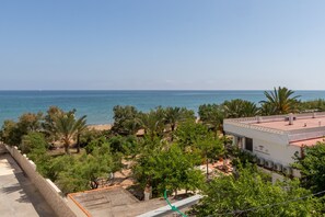 Une vue sur la côte, avec un bâtiment, des arbres et une plage.