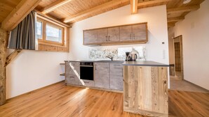 Una cocina con vigas de madera, horno empotrado y una isla grande.