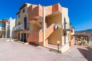 Un immeuble à plusieurs étages doté de balcons, d’un escalier et offrant une vue dégagée sur les environs.