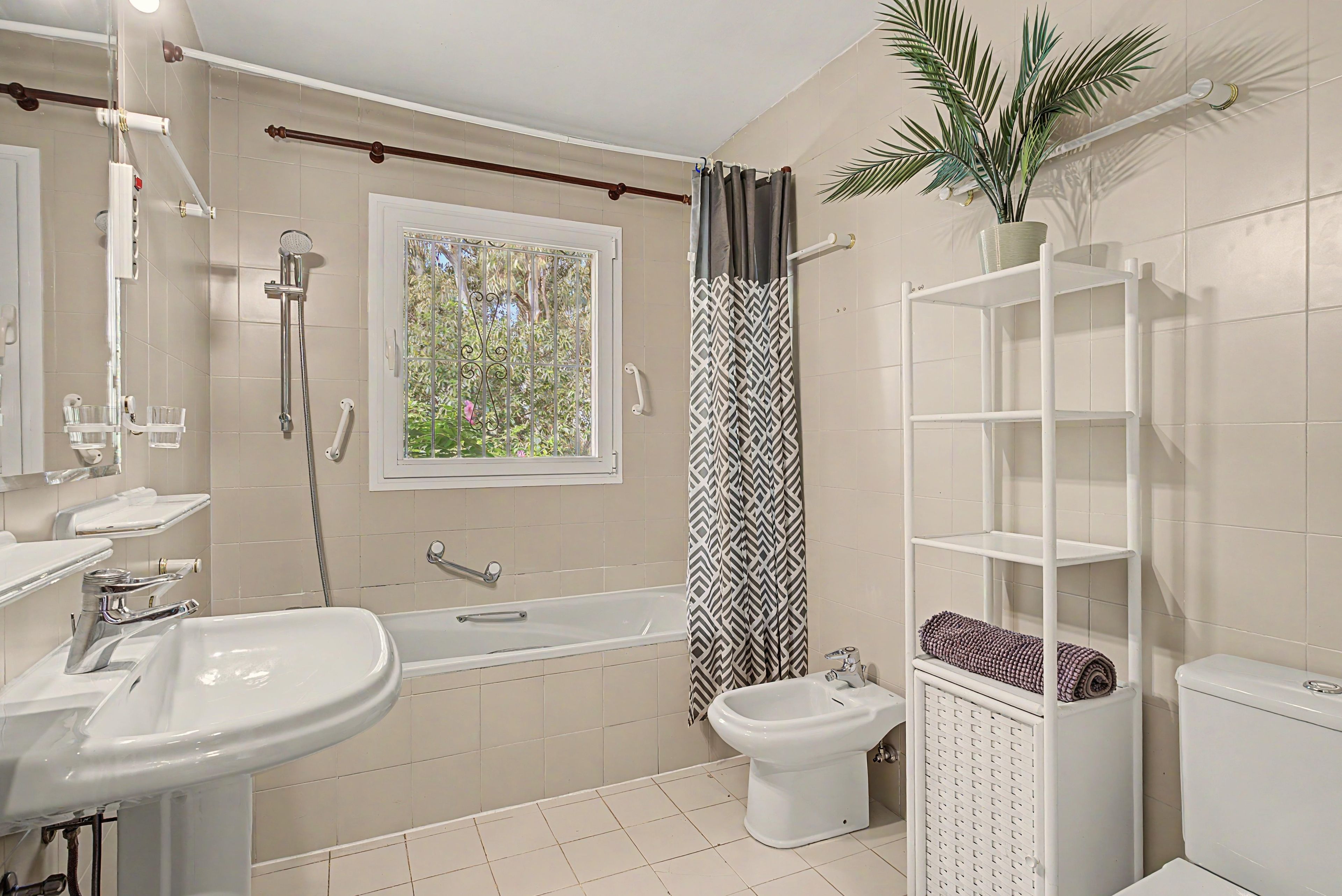 Une salle de bain équipée d’une baignoire, d’un bidet, de toilettes, d’un lavabo et d’une douche.
