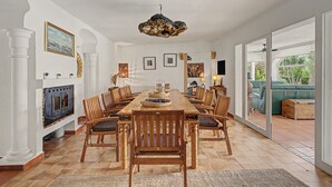 A dining room with a wooden table and chairs, a fireplace, and a view of the outdoors. - Casa Harriet with Pool, Terrace and WiFi (Mijas Pueblo)