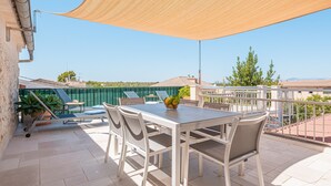 An outdoor patio with a table and chairs, a shade sail, and a view of the surrounding area. - Holiday Home Casa en Sineu with Mountain View, Terrace & Wi-Fi (Sineu)