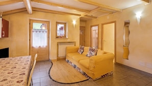 A cozy room with a sofa, a table, and a window. - Appartamento Giada with Mountain View, Balconies & Wi-Fi (Livigno)