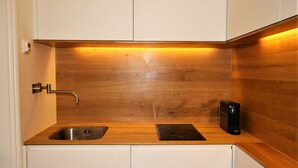 A kitchen with a wooden countertop, a stainless steel sink, and a black electric kettle. - Vacation apartment SeeFugium (Tegernsee)