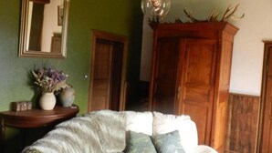 A cozy room with a white sofa, a wooden cabinet, and a mirror on the wall. - Farmhouse with pool, pets allowed in Sologne Bourbonnaise (Mercy)