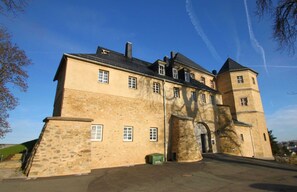 Ein großes Steinhaus mit zahlreichen Fenstern und einem zentralen Eingang.