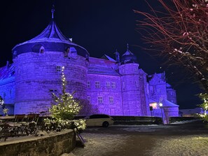 Historiallinen kivilinna, jossa on useita torneja ja lumipeitteinen sisäpiha.