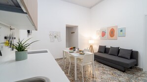 Un espacio habitable compacto con kitchenette, comedor y sofá.