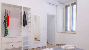 Een slaapkamer met een bed, een kledingkast, een spiegel en een raam.