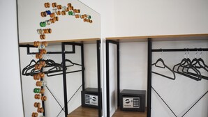 Ein Zimmer mit einer Spiegelwand, Holzböden und einem schwarzen Metallgestell mit Kleiderhaken.