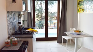Eine kleine Küche mit Essbereich, Blick nach draußen und einem Tisch mit einer Obstschüssel.