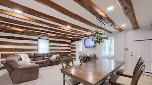 A room with a wooden ceiling, a dining table with chairs, a sofa, and a television. - Peaceful Hollow - Peaceful Hollow (Manchester)