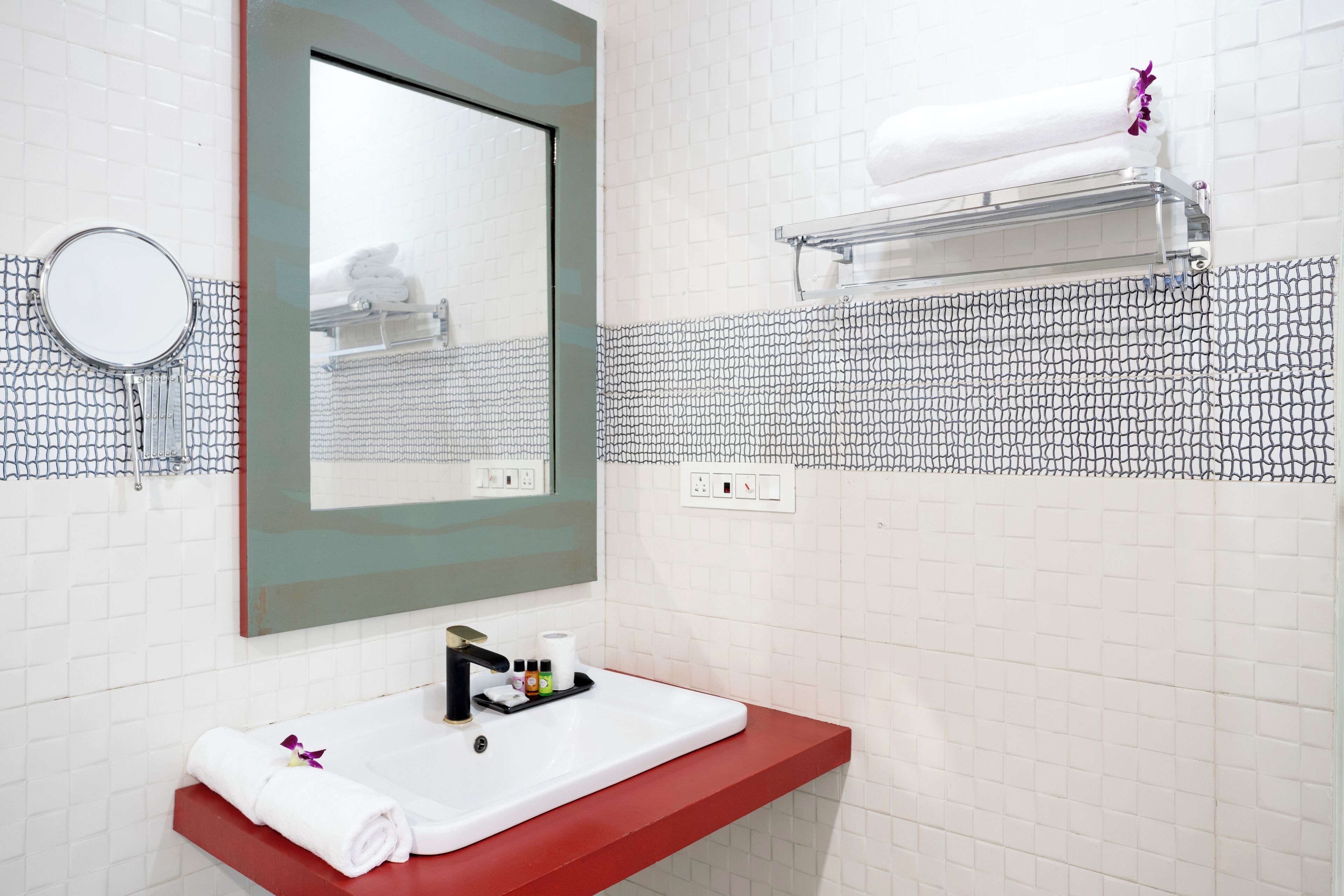 A bathroom with a white sink, a mirror, and a towel rack.